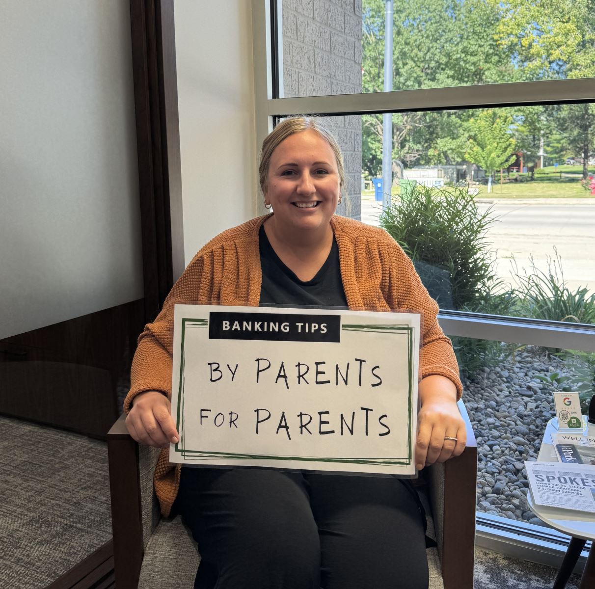 Cassie holding up the Banking Tips: By Parents for Parents sign.