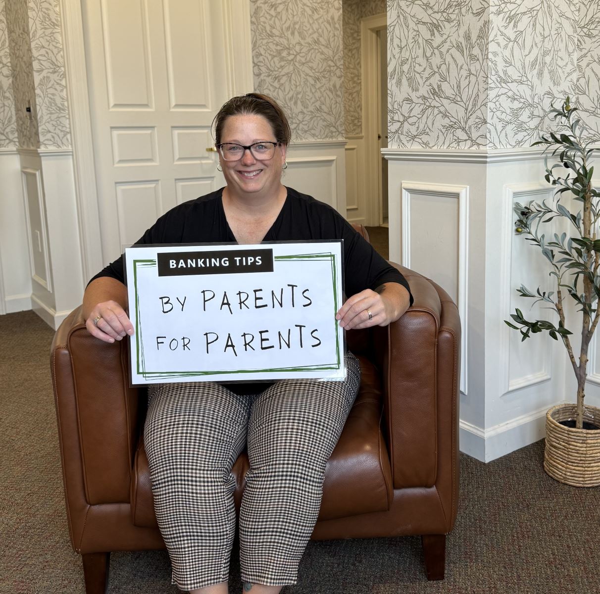 Dawn holding up the Banking Tips: By Parents for Parents sign.