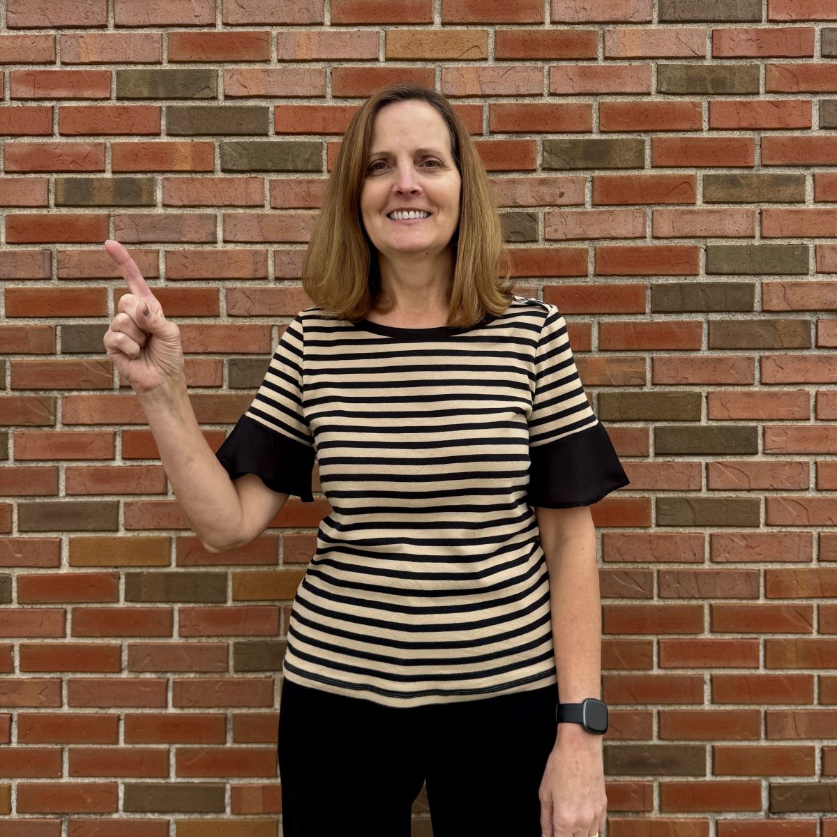 Diane holding up a one with her finger.