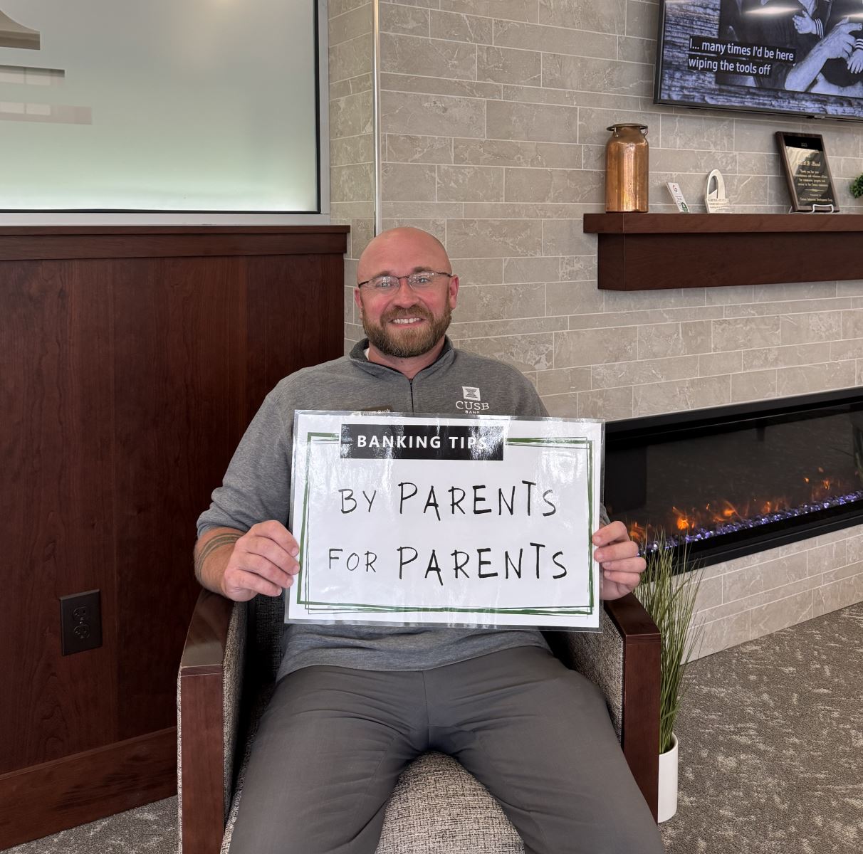 Evan holding up the Banking Tips: By Parents for Parents sign.