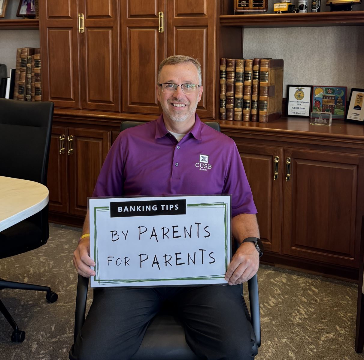 Kevin holding up the Banking Tips: By Parents for Parents sign.