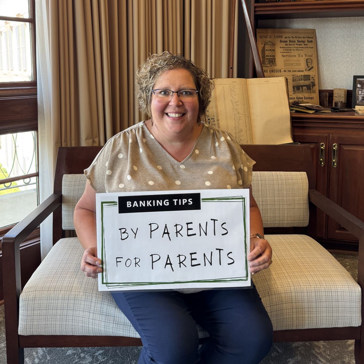 Laura holding up the Banking Tips: By Parents for Parents sign.