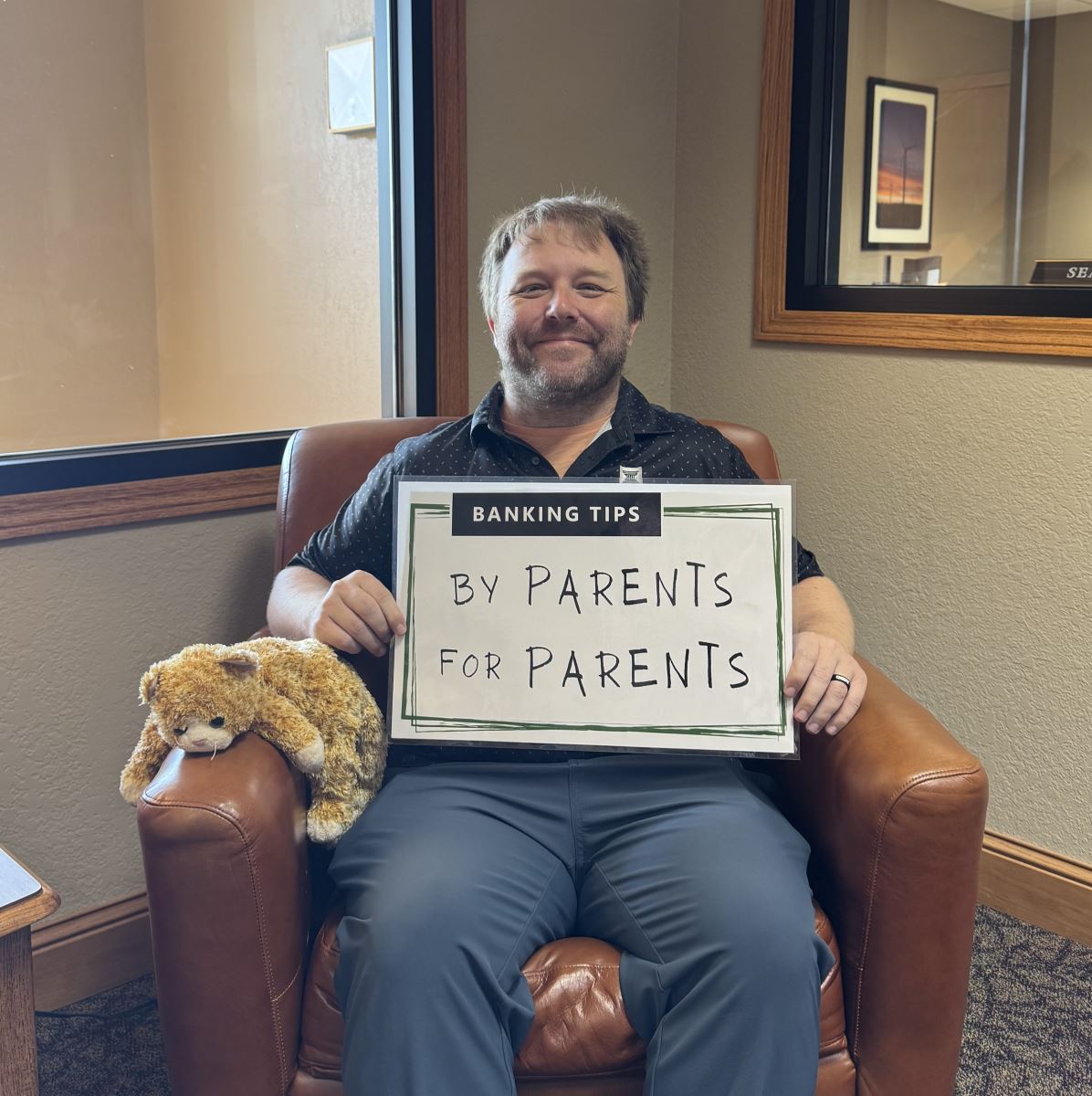 Shawn holding up the Banking Tips: By Parents for Parents sign.