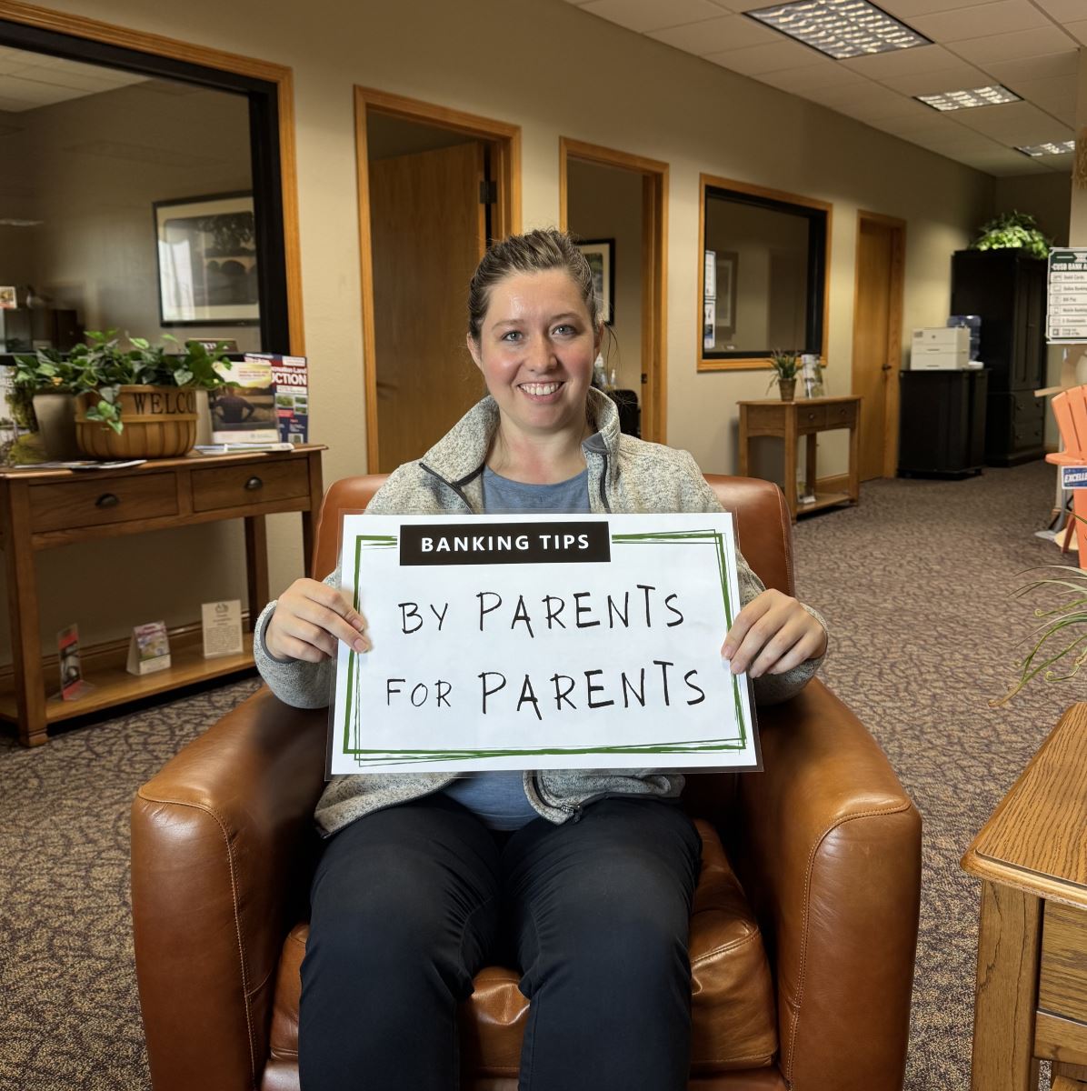 Tierney holding up the Banking Tips: By Parents for Parents sign.